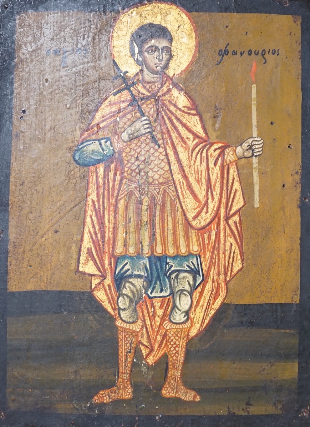 Greek School, tempera on wooden panel, Icon of a standing saint holding a candle, 33 x 24.5cm